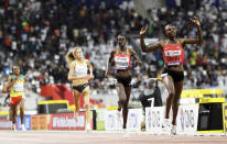 Hellen Obiri of Kenya, right, wins the gold medal in the women's 5000 meter final at the World Athletics Championships in Doha, Qatar, Saturday, Oct. 5, 2019. (AP Photo/Petr David Josek)