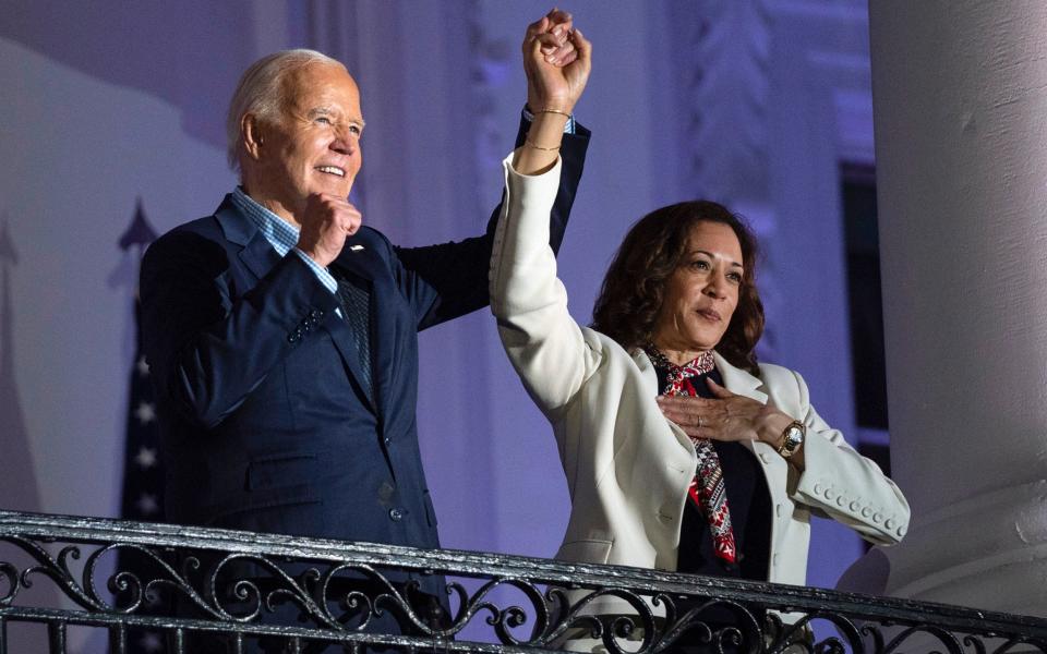 President Joe Biden raises the hand of Kamala Harris on the balcony of the White House on July 4
