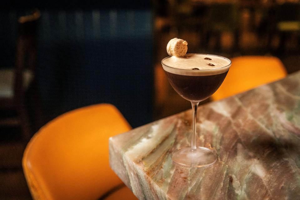 One of Jonathan Aviv's mini-macarons graces the rim of an espresso martini at Ela Curry & Cocktails restaurant in Palm Beach Gardens.