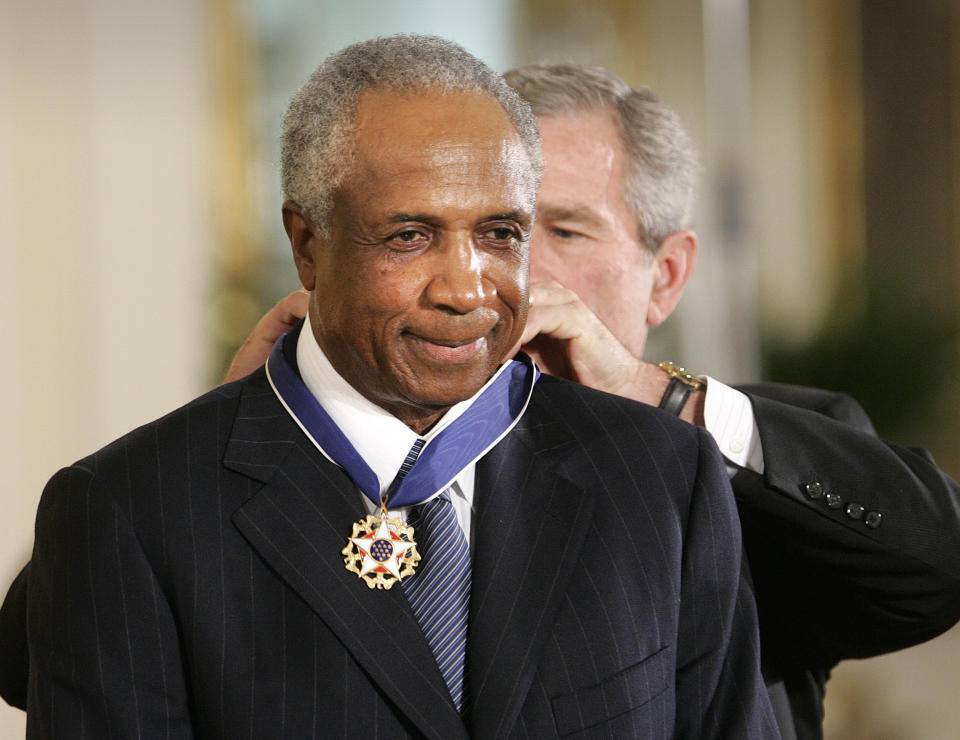 FILE - In this Nov. 9, 2005, file photo, President Bush awards baseball legend Frank Robinson the Presidential Medal of Freedom Award in the East Room of the White House in Washington. Hall of Famer Frank Robinson, the first black manager in Major League Baseball and the only player to win the MVP award in both leagues, died Feb. 7, 2019. He was 83. (AP Photo/Lawrence Jackson, File)