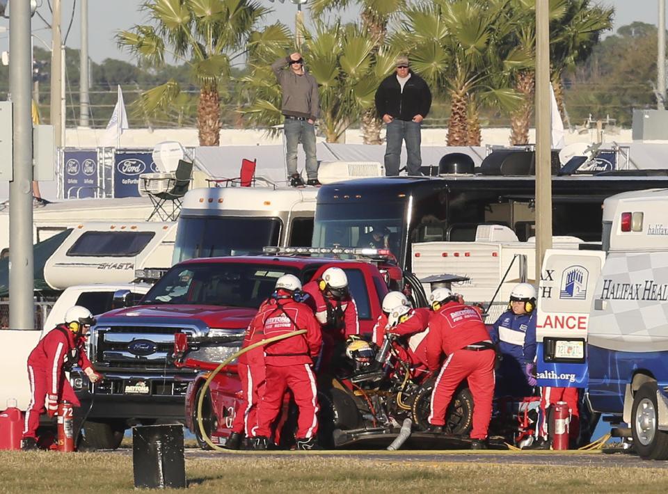 Rescue workers remove Memo Gidley, center, from his Corvette DP after he was involved in a crash during the IMSA Series Rolex 24 hour auto race at Daytona International Speedway in Daytona Beach, Fla., Saturday, Jan. 25, 2014. (AP Photo/David Graham)