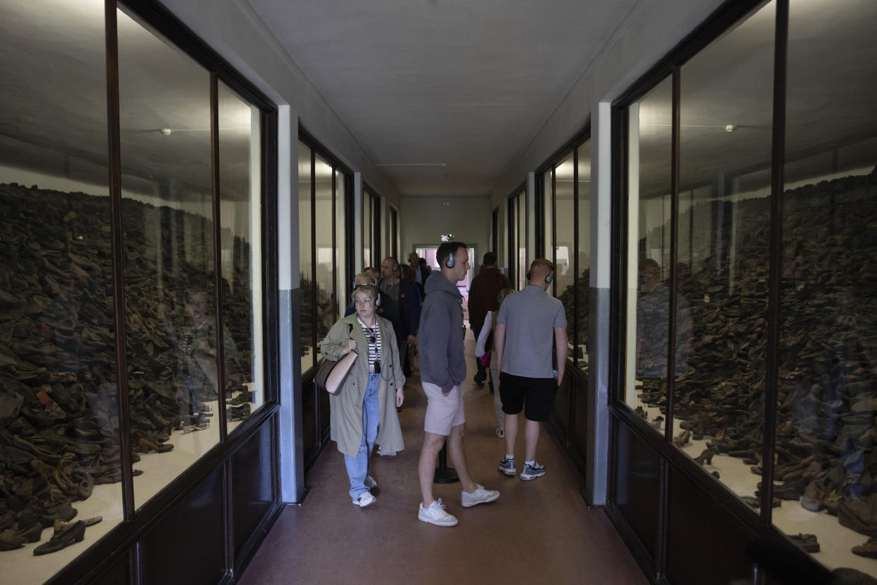 People visit one of the barracks displaying shoes collected from the prisoners of the former Nazi German death camp Auschwitz-Birkenau in Oswiecim, Poland, Wednesday, May 10, 2023. Elżbieta Cajzer, head of the collections, described the shoes as powerful testimony because the huge heaps of shoes that remain give some idea of the enormous scale of the crimes, even though what is left is only a fraction of what was. (AP Photo/Michal Dyjuk)