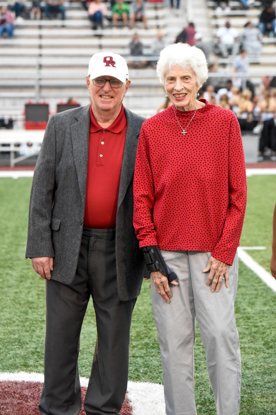 Dan DiGregorio, joined on Blankenship Field by his wife, Judy, is honored with a CareActer Award for his impact on the community and young people.