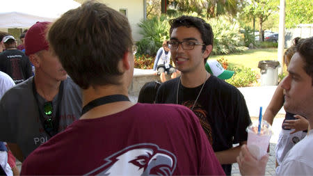 FILE PHOTO: Diego Pfeiffer is talking with some of his Marjory Stoneman Douglas High School classmates ahead of a memorial basketball game being played in honor of Joaquin Oliver, 17, who was killed during the shooting, in Parkland, Florida, U.S., in this still image from video on March 18, 2018. REUTERS/Jillian Kitchener/File Photo