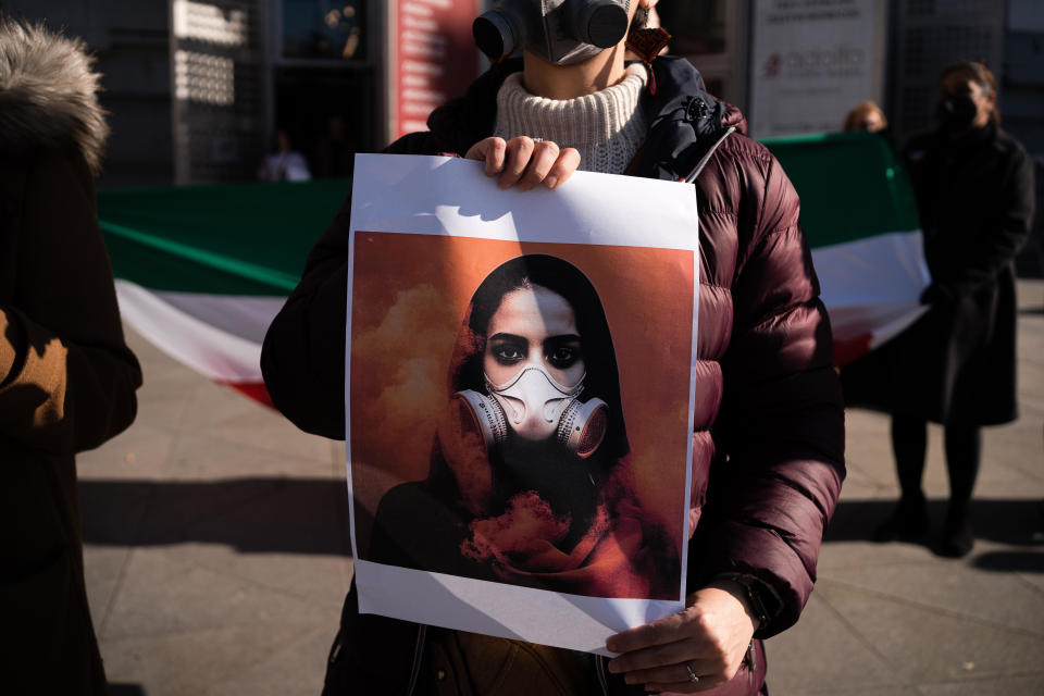 A woman holds a placard depicting a girl wearing a gas mask during a demonstration against hundreds of cases of girls being poisoned in schools in Iran, March 4, 2023 in Madrid, Spain. / Credit: Diego Radamas/SOPA Images/LightRocket/Getty