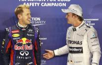 Red Bull Formula One driver Sebastian Vettel of Germany and Mercedes Formula One driver Nico Rosberg of Germany stand together after the qualifying session of the Singapore F1 Grand Prix at the Marina Bay street circuit in Singapore September 21, 2013. Vettel continued his imperious march towards a fourth consecutive Formula One world championship by storming to pole position at the Singapore Grand Prix on Saturday after dominating the two days of practice. REUTERS/Tim Chong (SINGAPORE - Tags: SPORT MOTORSPORT F1)