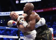 <p>Floyd Mayweather Jr. in action with Conor McGregor REUTERS/Steve Marcus </p>