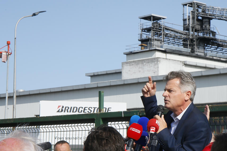 Communist party parliament member Fabien Roussel addresses Bridgestone employees outside the tire factory of Bethune, northern France, Thursday, Sept.17, 2020. Workers protest over the Japan-based company's decision to close the plant and lay off all its nearly 900 workers. Bridgestone argues the factory is no longer competitive globally, but unions and French politicians accused the company of using the virus-driven economic crisis as a pretext for the closure and not investing in modernizing the plant instead. (AP Photo/Michel Spingler)