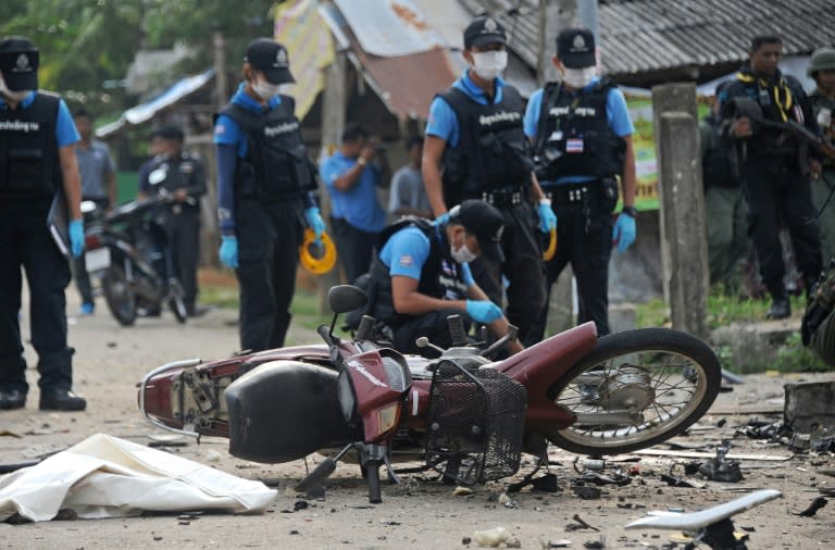 Bomb squad members inspect the site of a motorcycle bomb attack at a Buddhist village in the Rangae district of Thailand's restive southern province of Narathiwat, on September 18, 2015