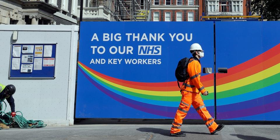 FILE - In this Thursday, May 7, 2020 file photo, a  construction worker passes a sign thanking the NHS in London, as the country in is lockdown to prevent the spread of coronavirus. The British economy grew by far less than anticipated during May, dampening hopes that the recovery from what is set to be one of the country’s deepest recessions in centuries will be rapid. The Office for National Statistics said Tuesday, July 14, 2020, that the economy grew by 1.8% in May from the previous month after some easing of the lockdown, such as encouraging those in construction or manufacturing to return to work.  (AP Photo/Kirsty Wigglesworth, File)