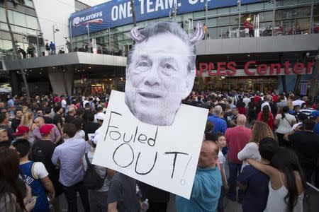 A supporter holds a photo cutout of Los Angeles Clippers owner Donald Sterling while standing in line for the NBA Playoff game 5 between Golden State Warriors and Los Angeles Clippers at Staples Center in Los Angeles, California April 29, 2014. REUTERS/Mario Anzuoni