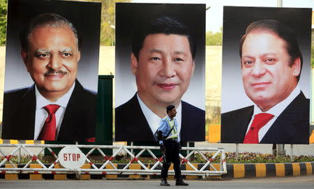 A policeman stands guard next to giant portraits of (L-R) Pakistan's President Mamnoon Hussain, China's President Xi Jinping, and Pakistan's Prime Minister Nawaz Sharif, displayed along a road ahead of Xi's visit to Islamabad April 19, 2015. REUTERS/Faisal Mahmood