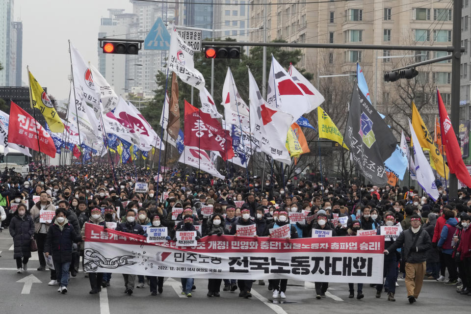 Members of the Korean Confederation of Trade Unions march to attend a rally against the government's labor policy near the National Assembly in Seoul, South Korea, Saturday, Dec. 3, 2022. Thousands of demonstrators representing organized labor marched in South Korea's capital on Saturday denouncing government attempts to force thousands of striking truckers back to work after they walked out in a dispute over the price of freight. The banner reads "National Workers's Rally." (AP Photo/Ahn Young-joon)