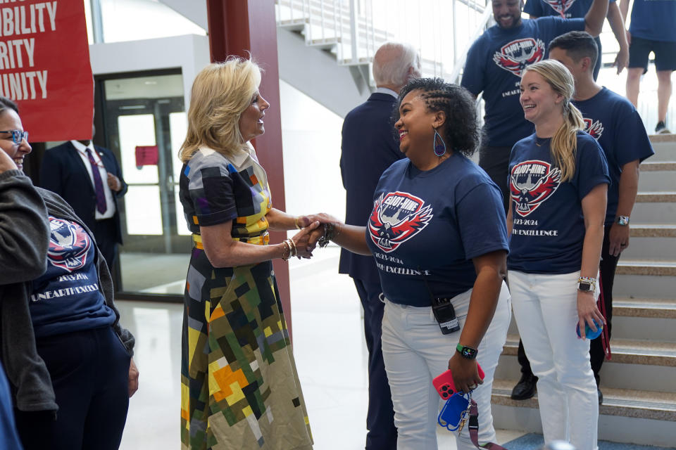 First lady Jill Biden and President Joe Biden, back to camera, meet staff at Eliot-Hine Middle School on Monday, Aug. 28, 2023, in Washington. The Bidens visited the school, located east of the U.S. Capitol, to mark the District of Columbia's first day of school for the 2023-24 year. (AP Photo/Manuel Balce Ceneta)