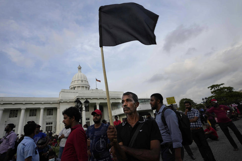 A supporter of Sri Lanka's opposition political party National People's Power carries a black flag during an anti-government protest rally in Colombo, Sri Lanka, Tuesday, April 19, 2022. Sri Lanka’s prime minister said Tuesday the constitution will be changed to clip presidential powers and empower Parliament as protesters continued to call on the president and his powerful family to quit over the country's economic crisis. (AP Photo/Eranga Jayawardena)