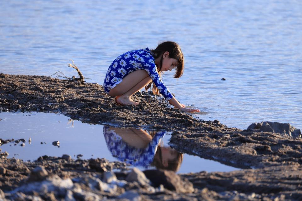 A kid plays with water as tourists enjoy the rare opportunity to see water as they visit Badwater Basin, the normally driest place in the US, in Death Valley National Park on Sunday.