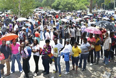 People wait for transport to take them to view the body of former South African President Nelson Mandela, who is lying in state, at the Union Buildings in Pretoria December 11, 2013. REUTERS/Mujahid Safodien