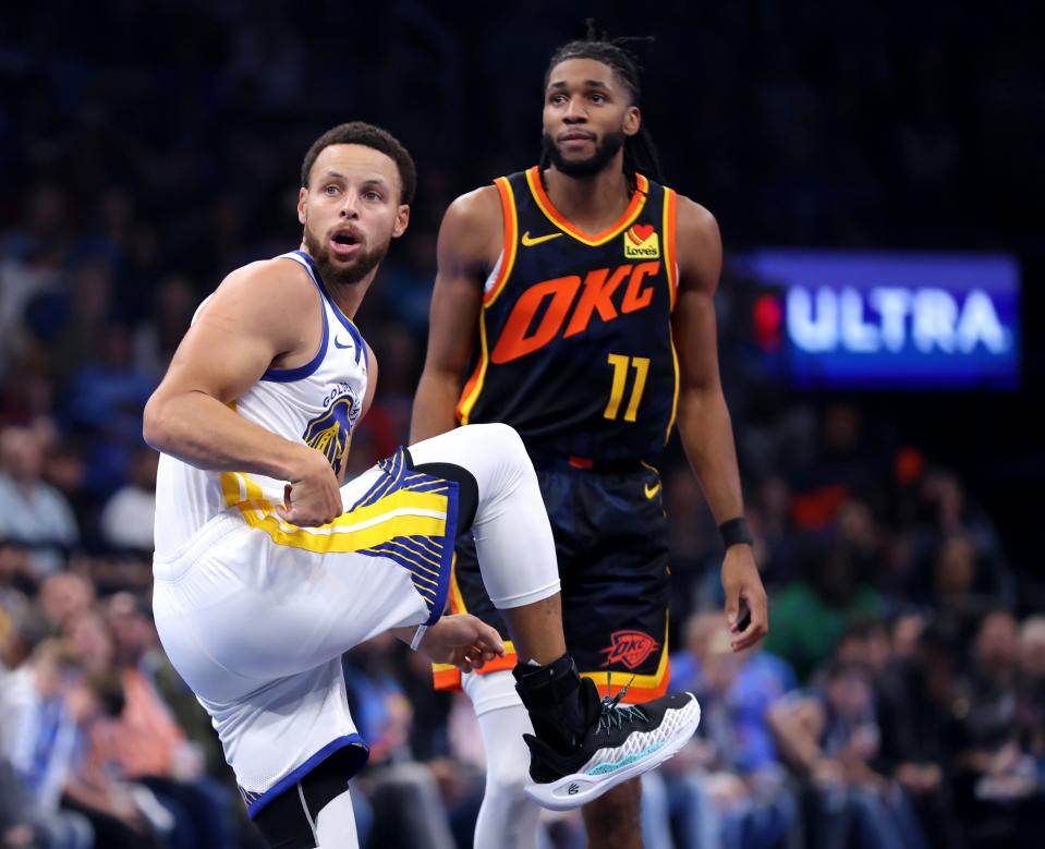 Warriors guard Stephen Curry (30) reacts after a 3-point basket in front of Thunder guard Isaiah Joe (11) during Golden State's 141-139 win Friday night at Paycom Center.