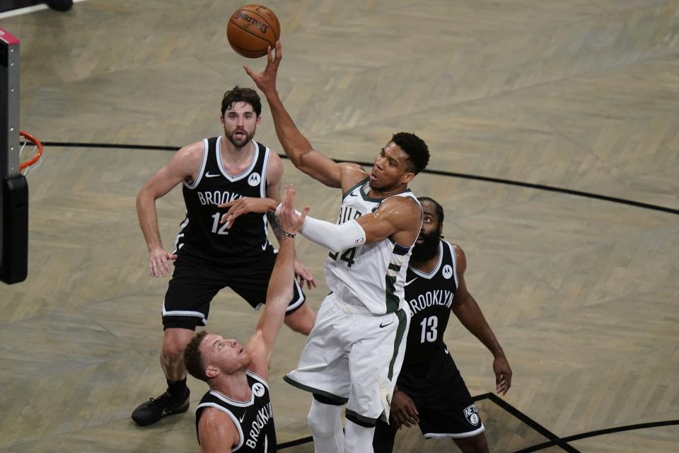 Milwaukee Bucks' Giannis Antetokounmpo (34) passes the ball away from Brooklyn Nets' Blake Griffin (2), James Harden (13) and Joe Harris (12) during the second half of Game 7 of a second-round NBA basketball playoff series Saturday, June 19, 2021, in New York. (AP Photo/Frank Franklin II)