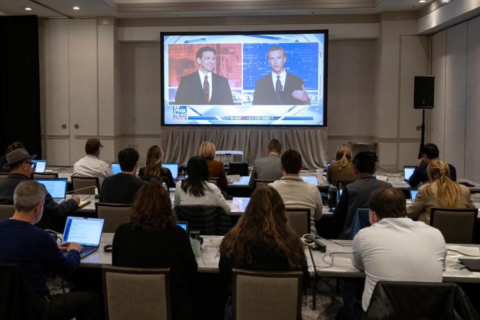 Florida Governor and Republican presidential hopeful Ron DeSantis (L) and California Governor Gavin Newsom (R) appear on screen from the press room during a debate held by Fox News, in Alpharetta, Georgia, on November 30, 2023 (AFP via Getty Images)