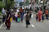 Residents flee from fighting between security forces and rebels from the Moro National Liberation Front (MNLF) who raided several villages in Zamboanga city, southern Philippines September 9, 2013. Rebels took 30 civilian hostages in the southern Philippines on Monday and held security forces in a standoff as part of a drive to derail peace talks, officials said. Police commandos cordoned off parts of Zamboanga City on the island of Mindanao after a rogue faction of the Moro National Liberation Front (MNLF) took hostages and tried to march to the city hall to raise their flag, an army commander said. REUTERS/STRINGER (PHILIPPINES - Tags: POLITICS MILITARY CIVIL UNREST)