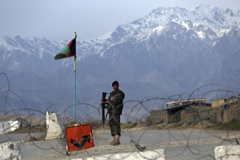 FILE - In this Wednesday, April 8, 2020, file photo, an Afghan National Army soldier stands guard at a checkpoint near the Bagram base north of Kabul, Afghanistan. The Taliban confirmed Sunday, April 12, 2020 that the group will release 20 Afghan government prisoners they were kept in their prisons. Suhial Shaheen, spokesman for the Taliban’s political office said in a tweet that the prisoners will be handed over to International Committee of the Red Cross ICRC in southern Kandahar province. (AP Photo/Rahmat Gul, File)