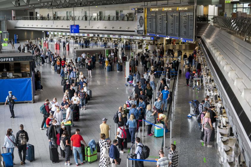 Passengers wait in line at an airport