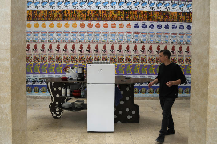 A man walks past the "Kitchenette" installation at the German pavilion, at the Biennale International Architecture exhibition, in Venice, Italy, Wednesday, May 17, 2023. The 18th edition of the Biennale International Architecture exhibition will open to the public from Saturday May 20 to Sunday Nov. 26, 2023. (AP Photo/Antonio Calanni)