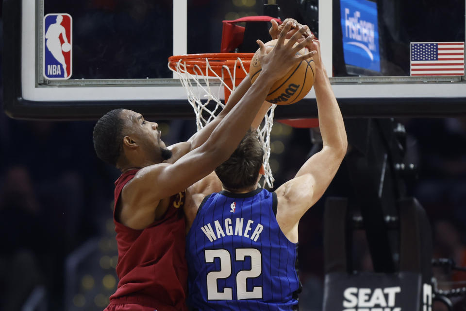 Cleveland Cavaliers center Evan Mobley (4) blocks a shot by Orlando Magic forward Franz Wagner (22) during the first half of a NBA basketball game, Wednesday, Oct. 26, 2022, in Cleveland. (AP Photo/Ron Schwane)