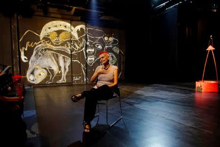 Theatre director Nelda Castillo speaks to actors (not pictured) after the play "¡Guan melón!, ¡tu melón!" beside a paint of Cuban street artist Yulier Rodriguez in a theatre in Havana, Cuba, October 20, 2017. REUTERS/Alexandre Meneghini