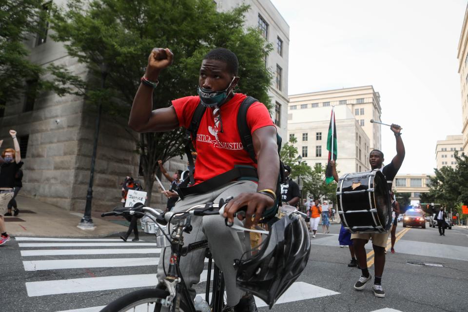 City Council candidate D. Marque Hall raises his fist as he rides alongside a group of around 50 Black Lives Matter protesters in Wilmington on Friday, Aug. 21, 2020.