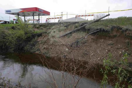 The banks of Beaver Brook, a source of large flooding, are eroded next to a gas station in Keene, New Hampshire May 16, 2014. REUTERS/Brian Snyder