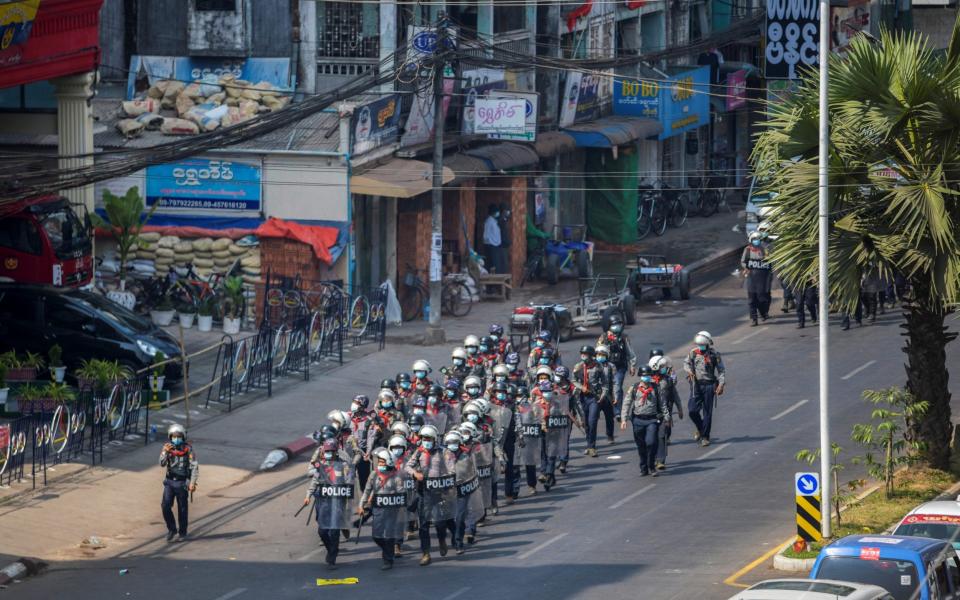 Riot police officers advance on pro-democracy protesters during a rally against the military coup in Yangon - REUTERS