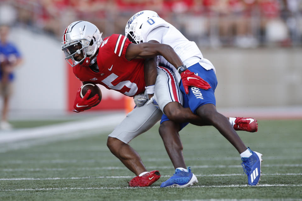 Tulsa defensive back Tyon Davis, right, tackles Ohio State receiver Garrett Wilson and during the first half of an NCAA college football game Saturday, Sept. 18, 2021, in Columbus, Ohio. (AP Photo/Jay LaPrete)