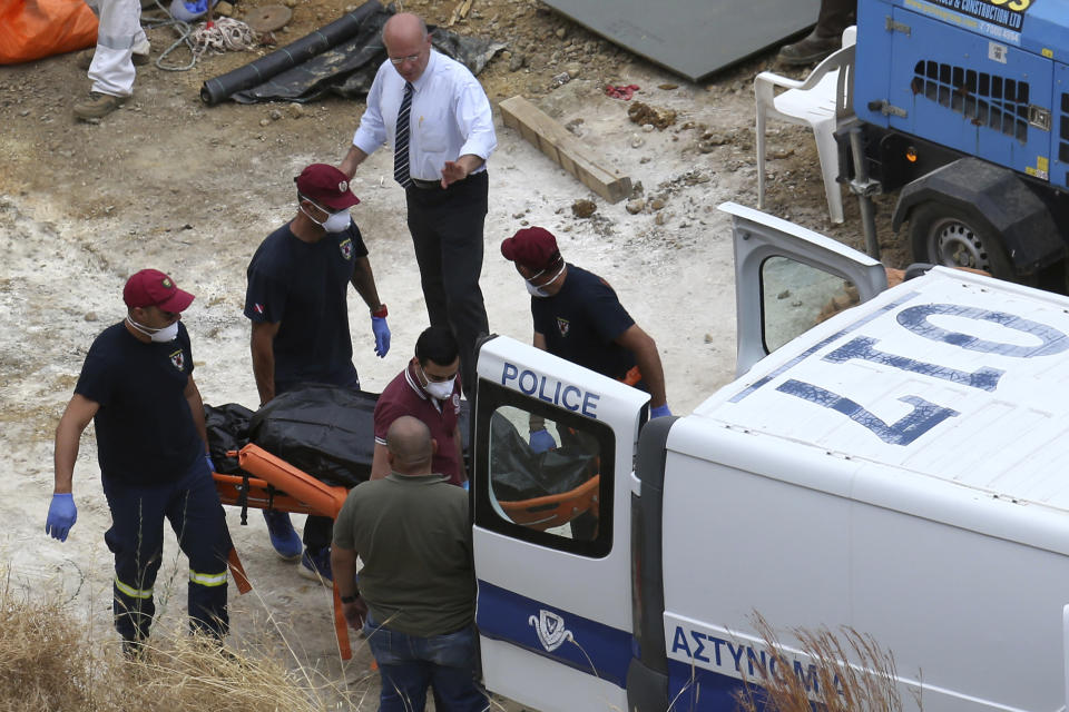 In this photo taken on Tuesday, June 4, 2019, Cyprus' Special Disaster Response Unit investigators carry a covered suitcase on a stretcher after it was retrieved from a man-made lake near the village of Mitsero, outside of the capital Nicosia, Cyprus. A Cyprus criminal court on Monday, June 24, 2019, has sentenced an army captain Nicholas Metaxas, 35, to seven life terms in prison after he pleaded guilty to the premeditated murder and kidnapping of seven foreign women and girls. (AP Photo/Petros Karadjias)