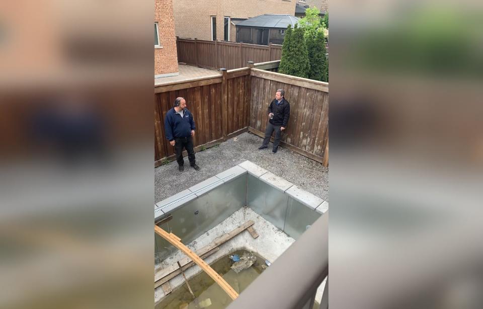 Gianni Evangelisti of Freedom Pools speaks to Michael Kushnirsky in the backyard of the Kushnirskys home in Maple.