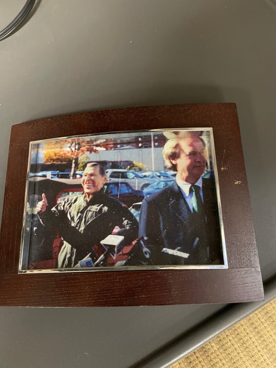 A photo in Patrick Crowley's office shows him wearing a George W. Bush mask and flight suit at a 2006 press conference held by then-Republican Sen. Lincoln Chafee, right.