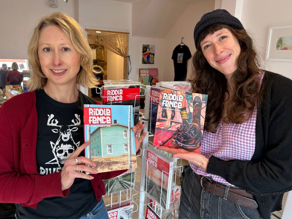 Elisabeth de Mariaffi, left, and Carmella Gray-Cosgrove show off copies of Newfoundland and Labrador arts and culture journal Riddle Fence at a pop-up store in downtown St. John's. (Anthony Germain/CBC - image credit)