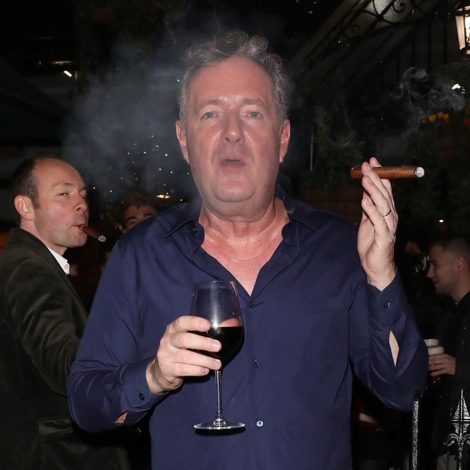 Piers Morgan puffs on a cigar at his Christmas party at the Scarsdale Tavern in Kensington on Friday night