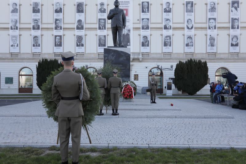 Soldiers carry wreaths in front on the monument of late Polish President Lech Kaczynski