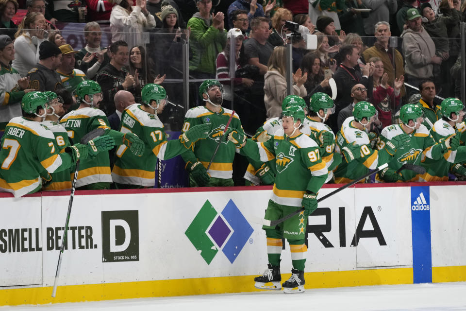 Minnesota Wild left wing Kirill Kaprizov (97) celebrates with teammates after scoring during the second period of an NHL hockey game against the Boston Bruins, Saturday, Dec. 23, 2023, in St. Paul, Minn. (AP Photo/Abbie Parr)