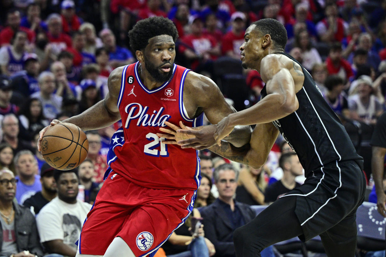 Philadelphia 76ers' Joel Embiid, left, dibbles the ball as Brooklyn Nets' Nic Claxton defends in the second half during Game 1 in the first round of the NBA basketball playoffs, Saturday, April 15, 2023, in Philadelphia. (AP Photo/Derik Hamilton)