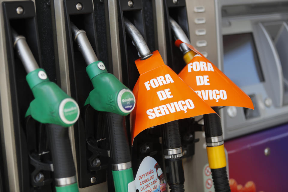 Signs reading in Portuguese "out of order" are attached to diesel pumps at a gas station serving diesel only to government designated priority vehicles, such as emergency services, in Lisbon, Monday, Aug. 12, 2019. Portugal is rationing gas as a precaution after some 2,000 tanker truck drivers began an open-ended strike over pay on Monday. The government has set a limit of 25 liters (6.6 gallons) for customers at gas stations until further notice. (AP Photo/Armando Franca)