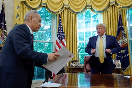 El viceprimer ministro de China, Liu He, entrega una carta del presidente de China, Xi Jinping, al presidente de los Estados Unidos, Donald Trump, durante una reunión en la Oficina Oval de la Casa Blanca en Washington.