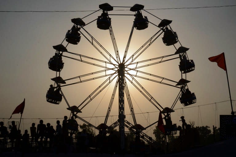 <p>Indian people sit on a ride at fair ground in Amritsar on October 11, 2016. </p>