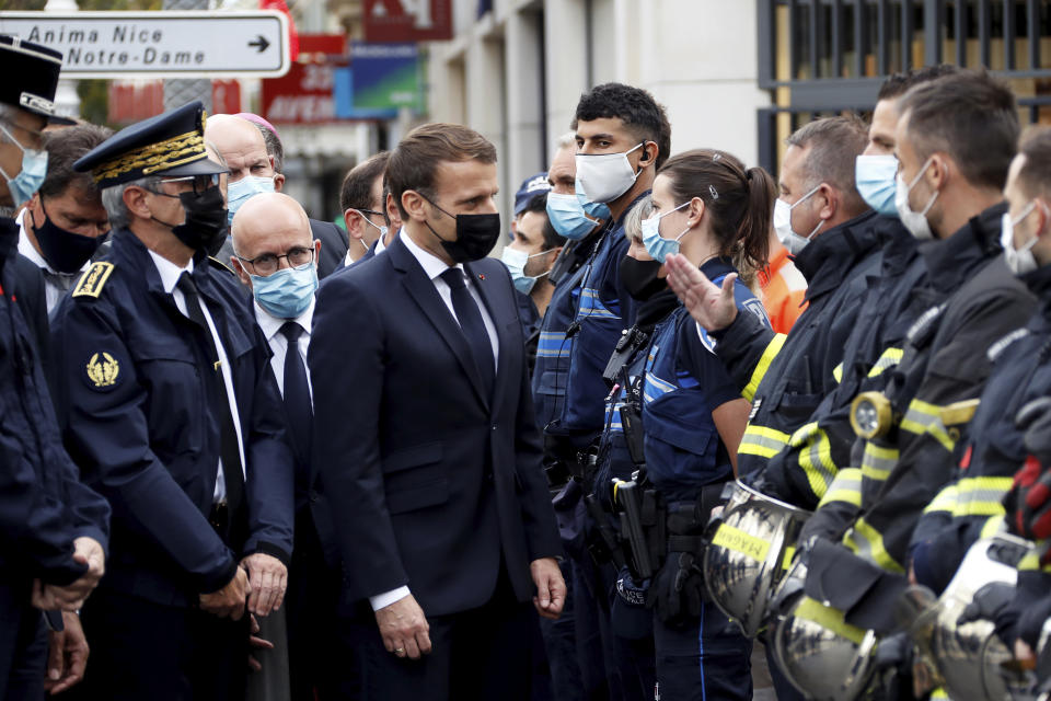 French President Emmanuel Macron (centre) with police officers and rescue workers after a knife attack at Notre Dame church in Nice.