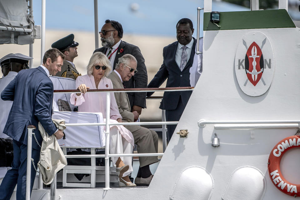 Britain's King Charles III, center, and Queen Camilla arrive aboard the Admiral's Barge to meet Royal Marines and Kenyan Marines at Mtongwe Naval Base, in Mombasa, Kenya, Thursday, Nov. 2, 2023. (Luis Tato/Pool Photo via AP)