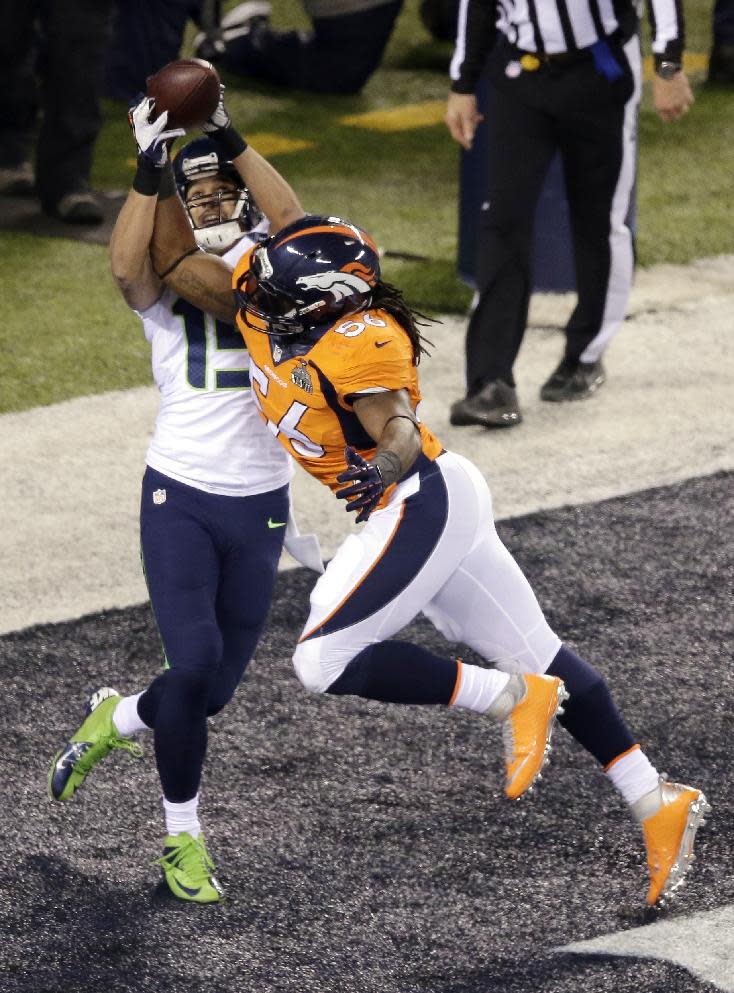 Denver Broncos' Nate Irving (56) breaks up a pass to Seattle Seahawks' Jermaine Kearse (15) during the first half of the NFL Super Bowl XLVIII football game Sunday, Feb. 2, 2014, in East Rutherford, N.J. (AP Photo/Charlie Riedel)