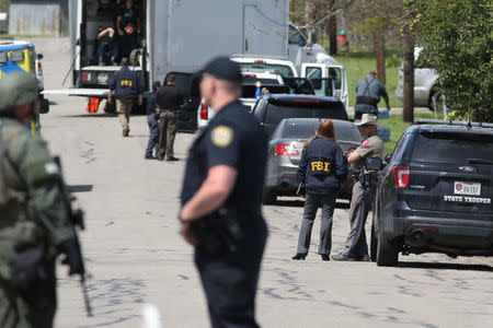 Law enforcement personnel investigate a neighborhood containing the home where the bomber was suspected to have lived in Pflugerville, Texas, U.S., March 21, 2018. REUTERS/Loren Elliott