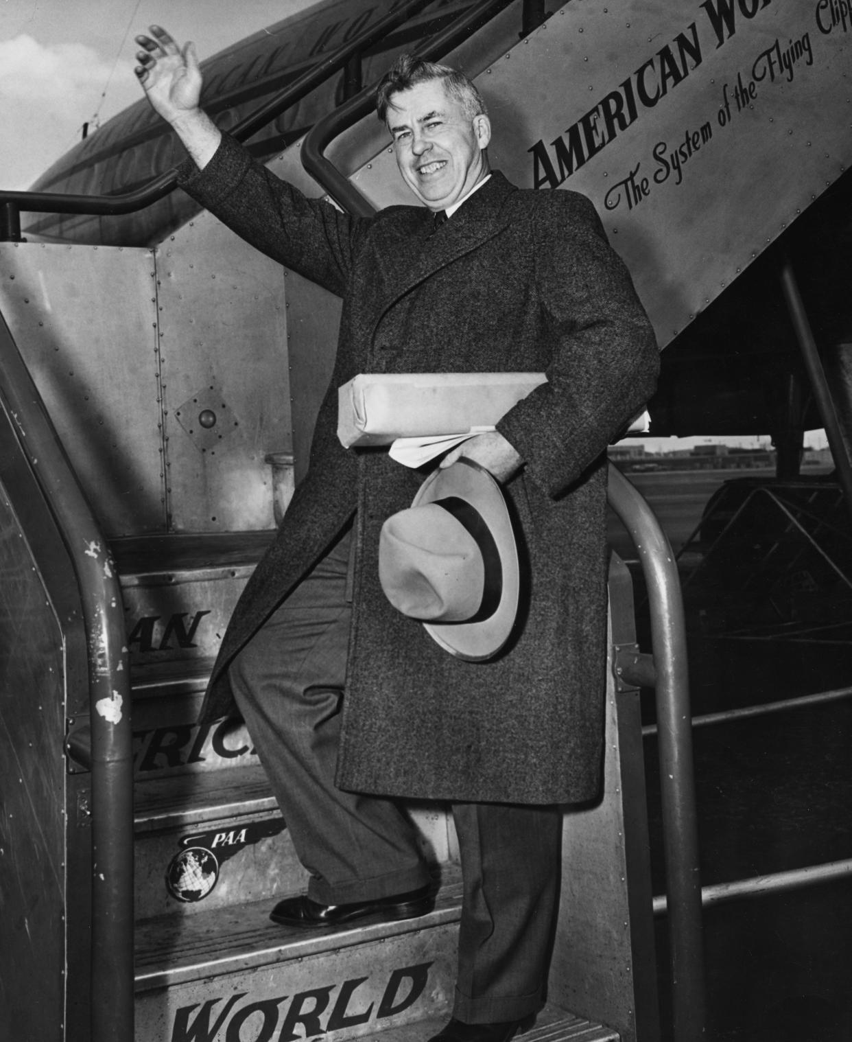 Henry A. Wallace waving as he boards a Pan Am airliner bound for London, circa 1950.